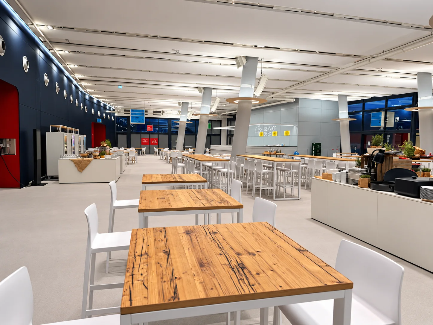 Blick entlang der Hochtische und weißen Barhocker zwischen Buffetstationen im Cruise Center HafenCity