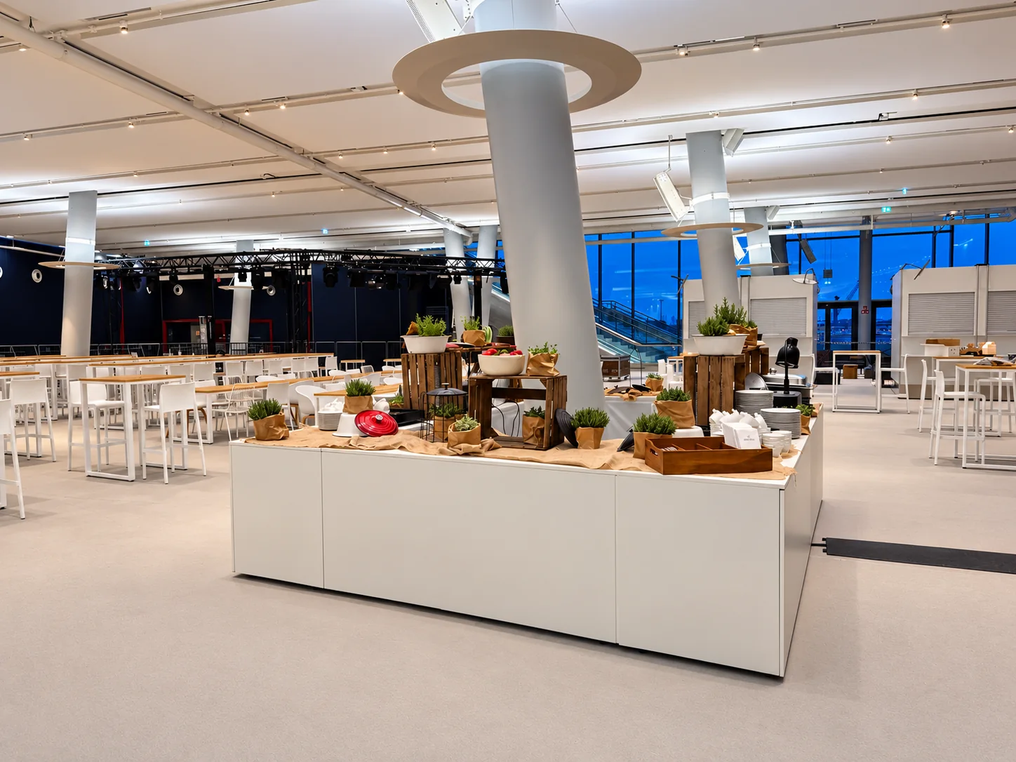 Weiße Buffetinsel mit Holzaufbauten und Geschirr vor den Hochtischen im Cruise Center HafenCity