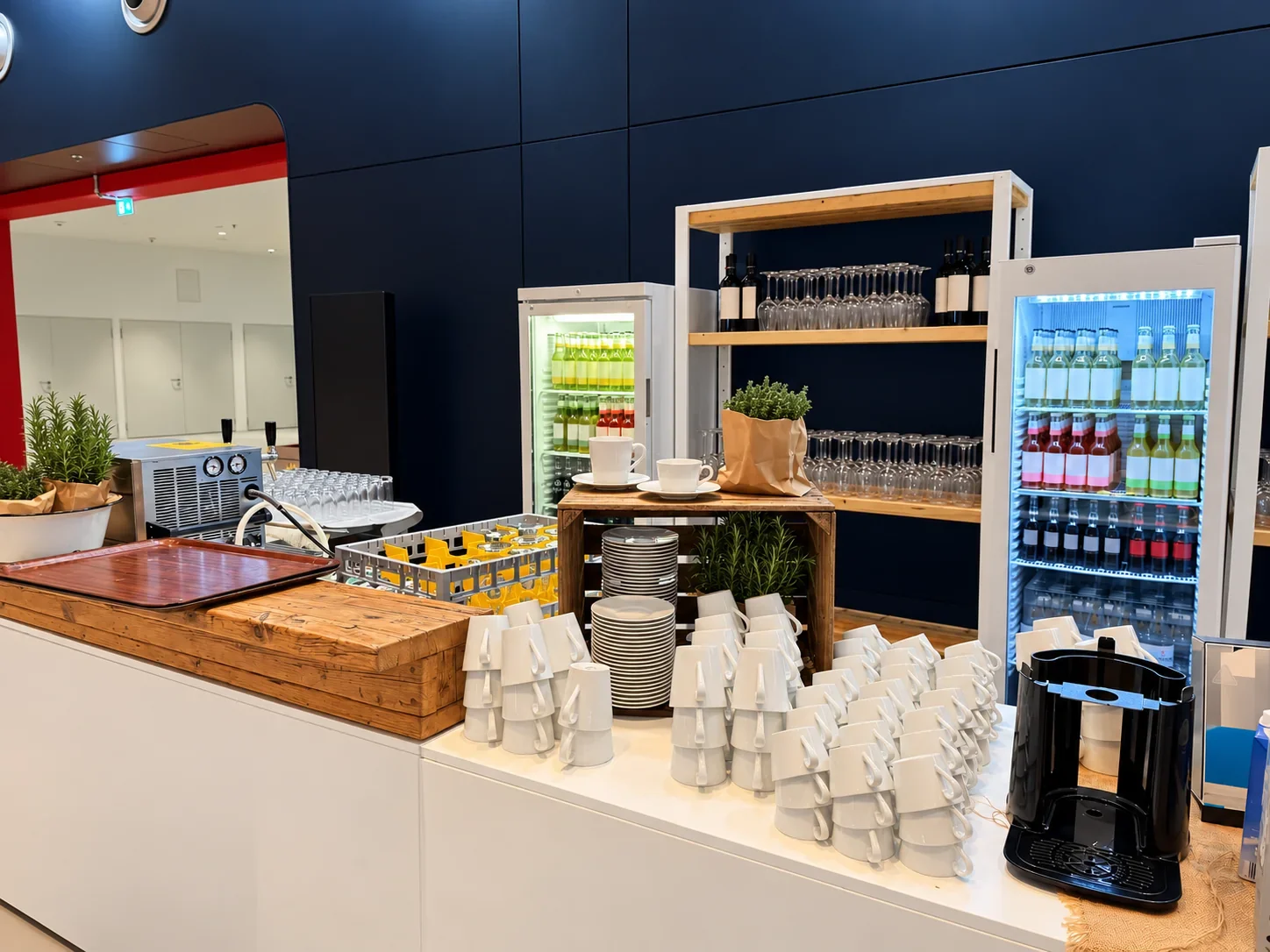 Kaffee- und Getränkestation mit gestapelten weißen Tassen und Regalen im Cruise Center HafenCity