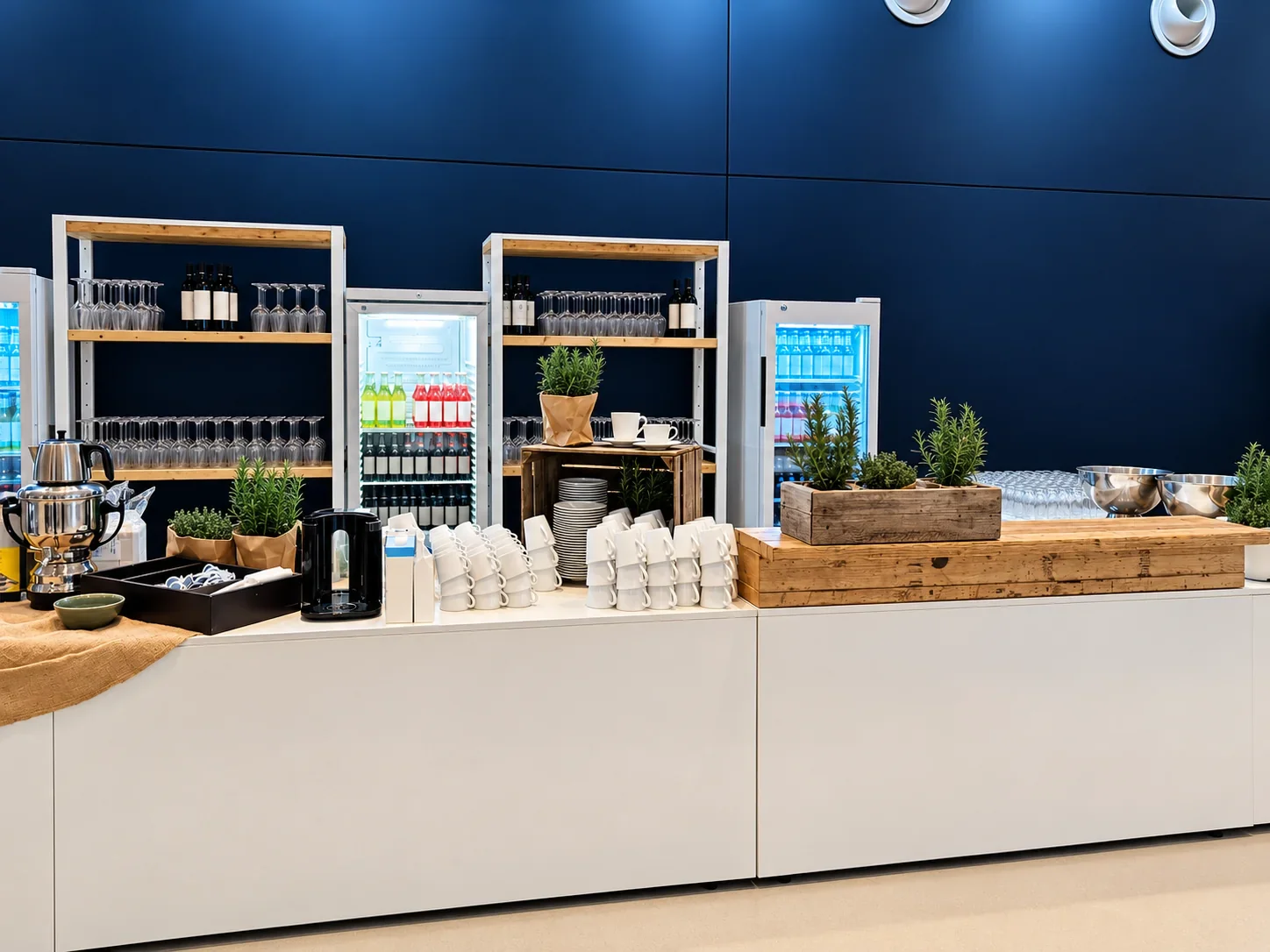 Frontansicht der weißen Kaffeetheke mit Holzaufbauten, Tassen und Gläserregalen im Cruise Center HafenCity