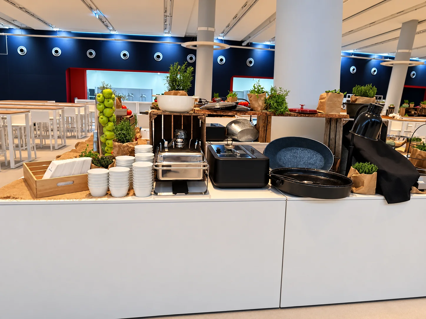Detail einer weißen Buffetinsel mit Schalen, Servietten, Holzaufbauten und grünen Äpfeln im Cruise Center HafenCity